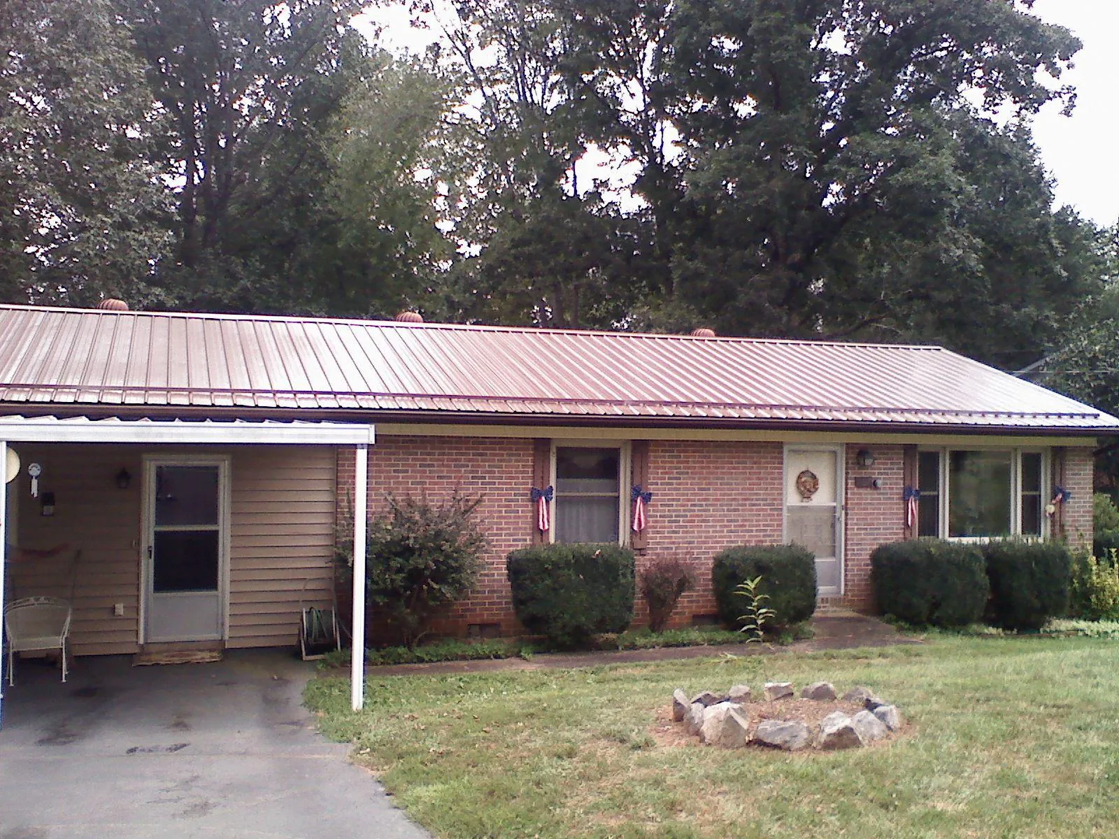 Bronze metal roof and carport on a brick ranch home — Roof Repair work by our crew in Cumming